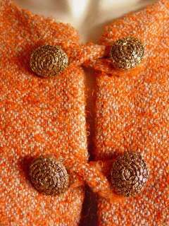   in orange and camel wool boucle tweed features a short raglan sleeved