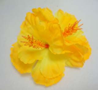   bright yellow hibiscus flowers are back to back on an alligator clip