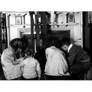 Children Gathered in Front of Fireplace Hung with Stockings, Waiting 