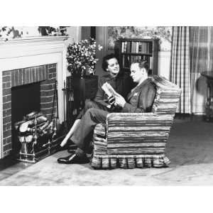  Couple Sitting on Armchair in Front of Fireplace, (B&W 